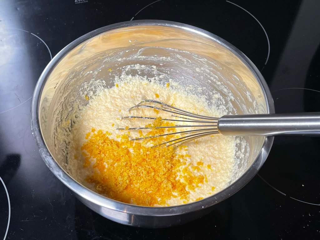 Citrininis keksas, subertos citrinų žievelės ir supiltos jų sultys