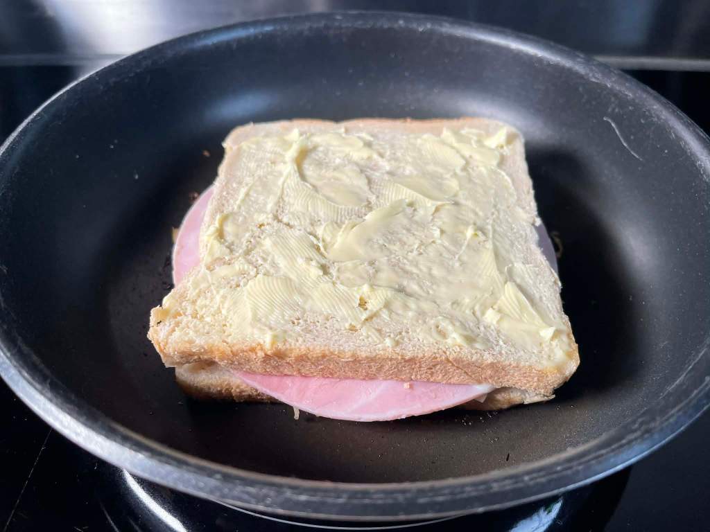Croque-monsieur karštas sumuštinis skrudinamas keptuvėje