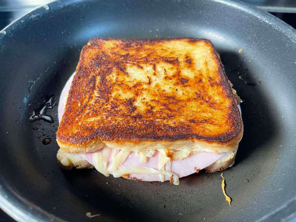 Croque-monsieur karštas sumuštinis apskrudintas keptuvėje
