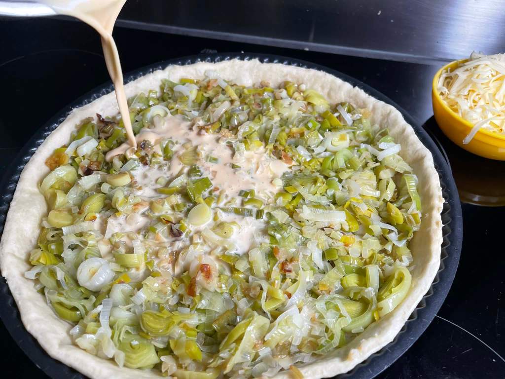 Ant kišo tešlos pagrindo paskirstytų porų pilamas kiaušinių ir grietinėlės plakinys