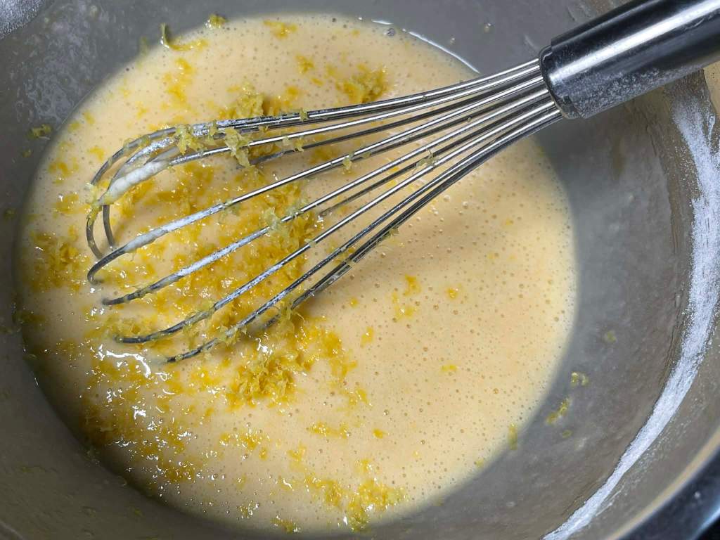 Madlenai su citrina, tarkuota citrinos žievelė sudėta į tešlą dubenyje