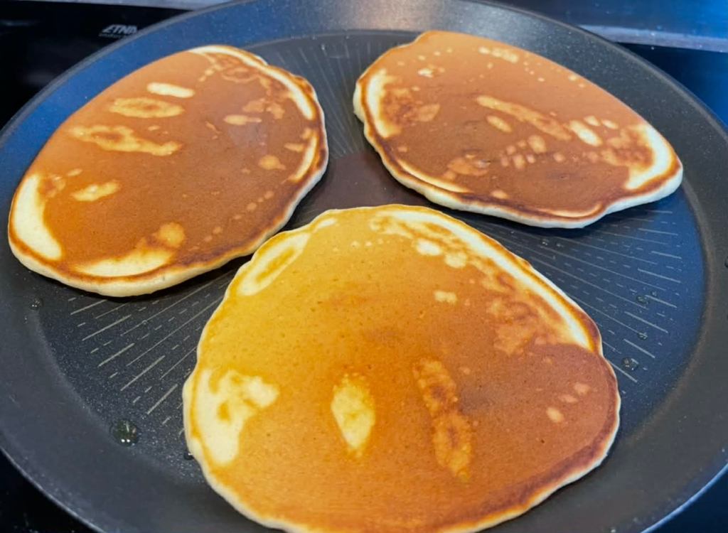 Purūs amerikietiški blynai (Pancakes) jau apversti kepami keptuvėje
