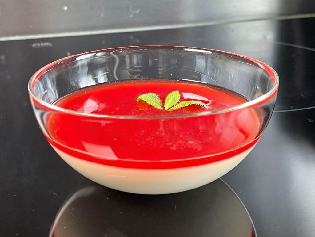 Klasikinis itališkas desertas Panna Cotta indelyje su braškių uogiene.