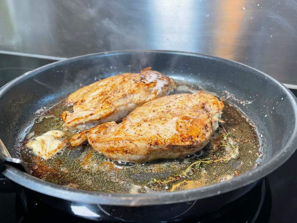 Vištienos krūtinėlė, jau apversta, kepa svieste keptuvėje