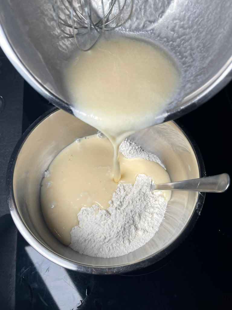 Mufinai, išplakti šlapi ingredientai pilami į išmaišytus sausus ingredientus dubenyje
