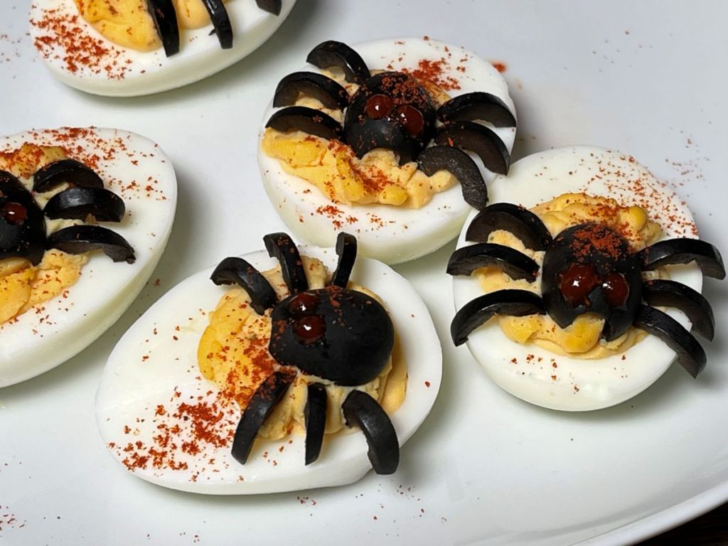 Velnio kiaušiniai įdaryti pikantišku įdaru, su voriukais iš juodųjų alyvuogių, apibarstyti rūkyta paprika.
